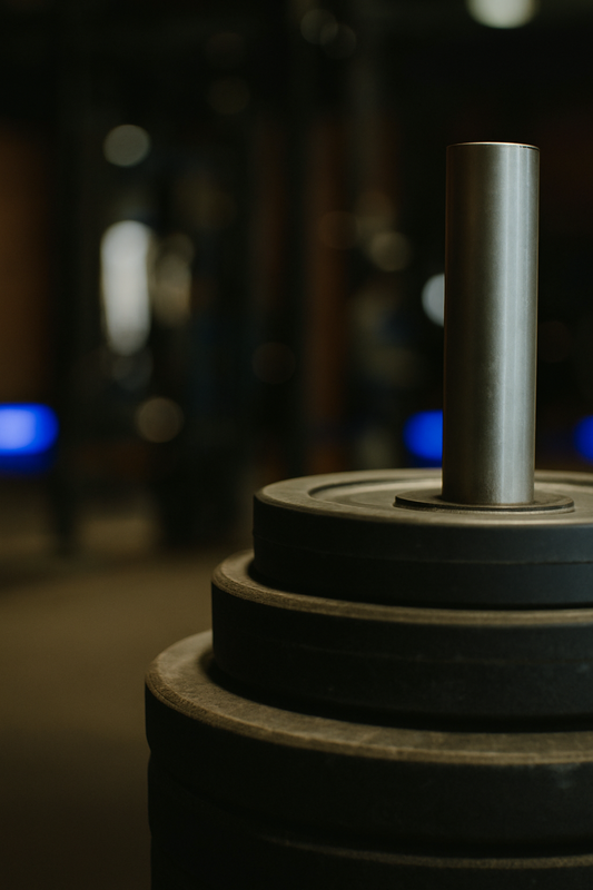  A woman standing in a quiet gym, focused on her workout in front of a mirror, wearing neutral activewear. The soft lighting and minimalist setting convey calm, focus, and self-improvement.