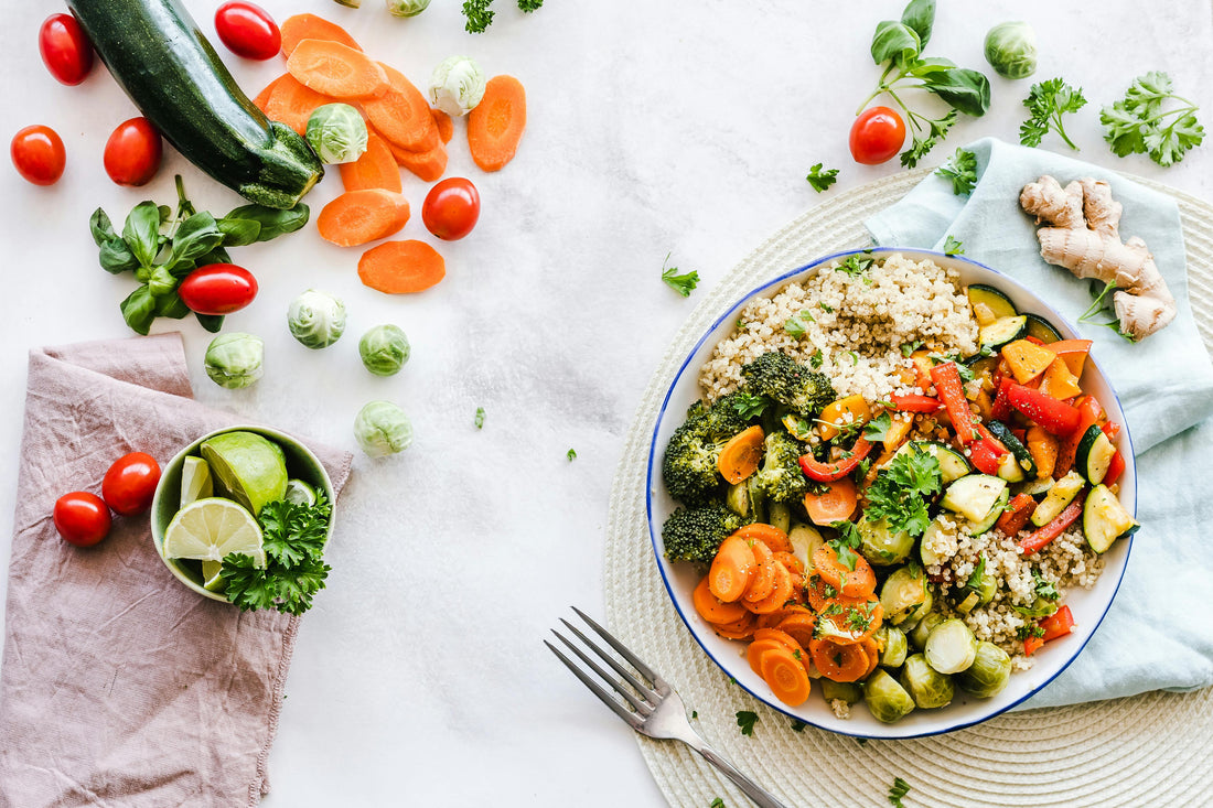  bowl of quinoa and roasted vegetables on neutral background with fresh ingredients around
